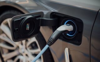 Elektroauto mit eingestecktem Ladekabel am geöffneten Ladeanschluss