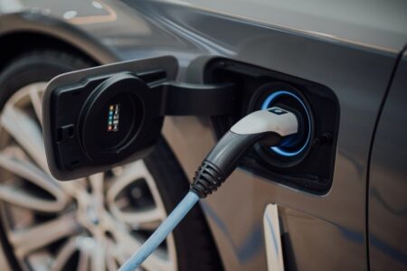 Elektroauto mit eingestecktem Ladekabel am geöffneten Ladeanschluss