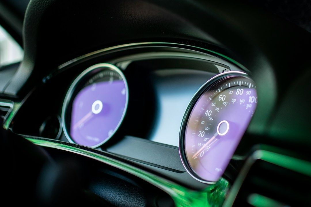 Nahaufnahme eines digitalen Fahrzeugcockpits mit zwei violetten Rundanzeigen