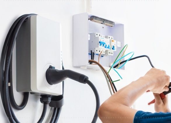 Wallbox und geöffneter Sicherungskasten bei Elektroinstallationsarbeiten